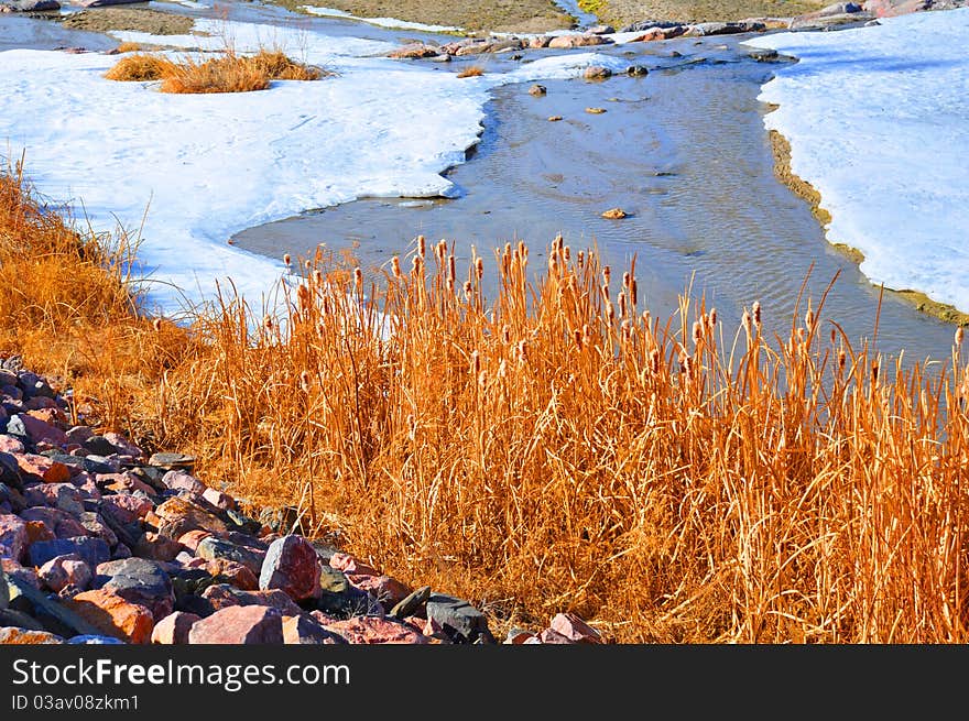 This babbling stream meanders through the woods in a snowy winter's field. This babbling stream meanders through the woods in a snowy winter's field