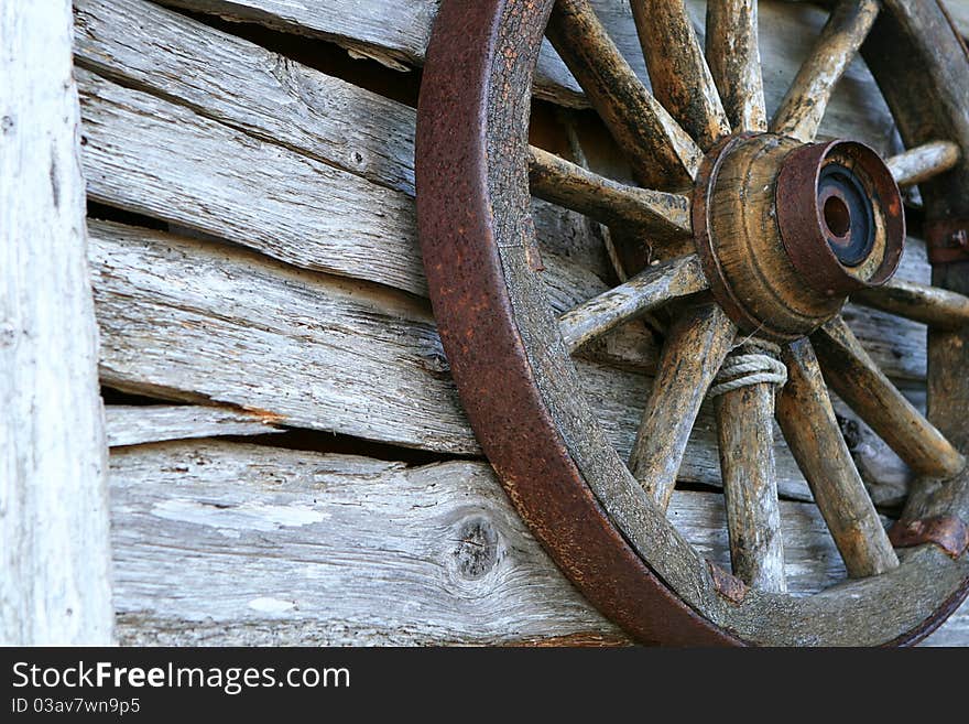 Spoked old wheel on a wooden wall