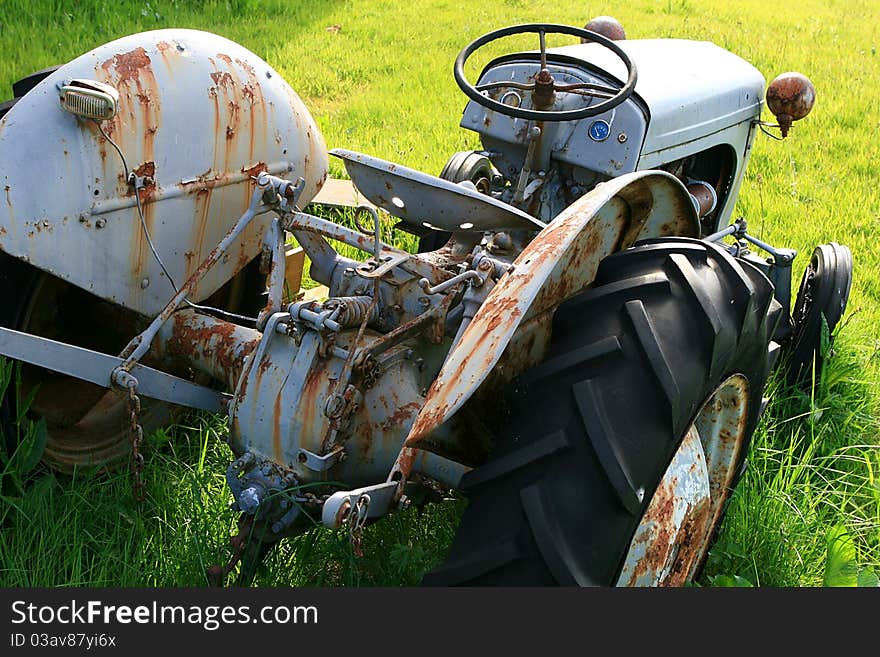 Oldtimer tractor, wrecked on a green lawn