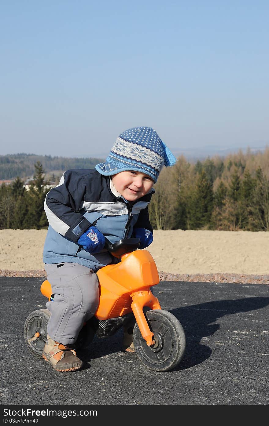 Little child riding a toy motorbike during an afternoon walk. Little child riding a toy motorbike during an afternoon walk