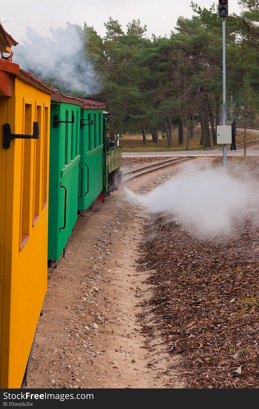 An old steam train pulls colorful waggons