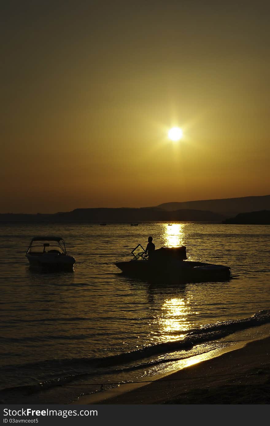 Sunset at sandy beach, man and two boats. Sunset at sandy beach, man and two boats.