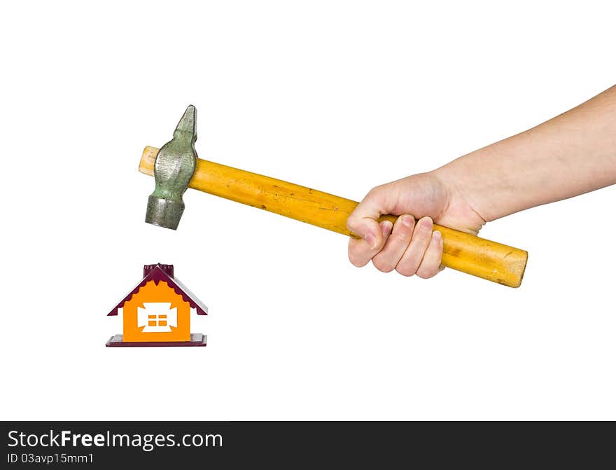 Hand with a hammer destroys small house. Hand with a hammer destroys small house