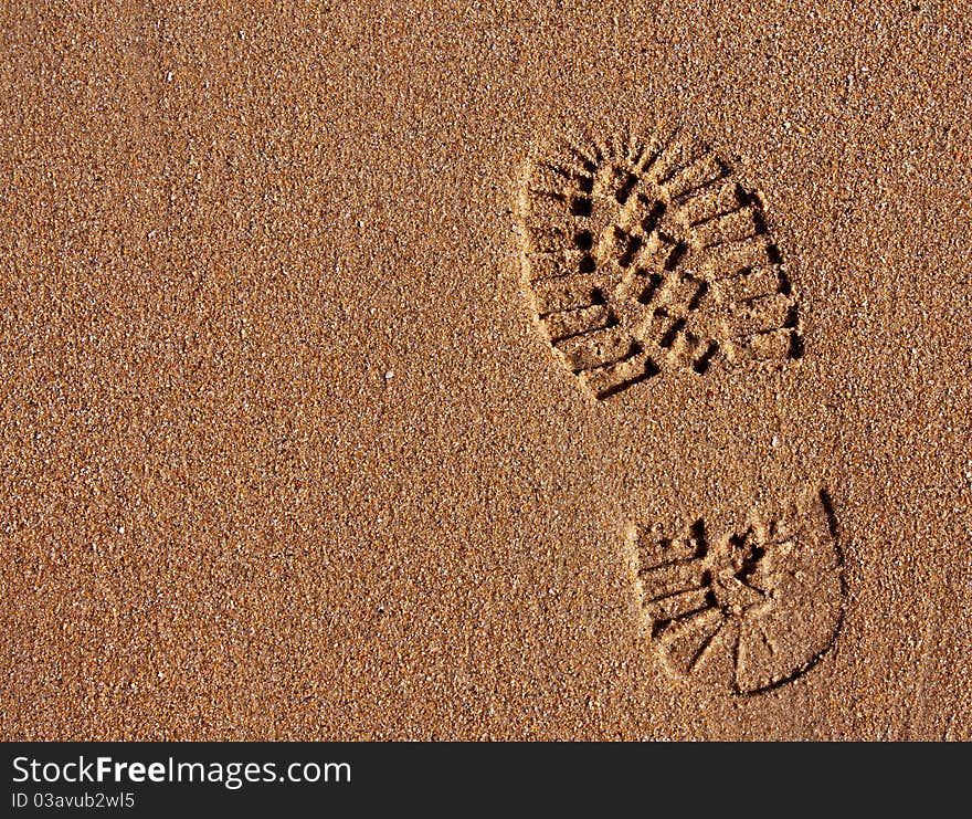 Footprint in the golden wet sand of a clean beach. Footprint in the golden wet sand of a clean beach