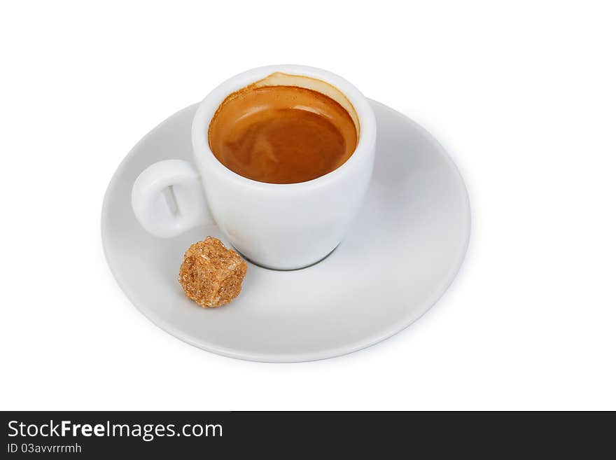 A cup of coffee on a saucer and a piece of cane sugar. A cup of coffee on a saucer and a piece of cane sugar