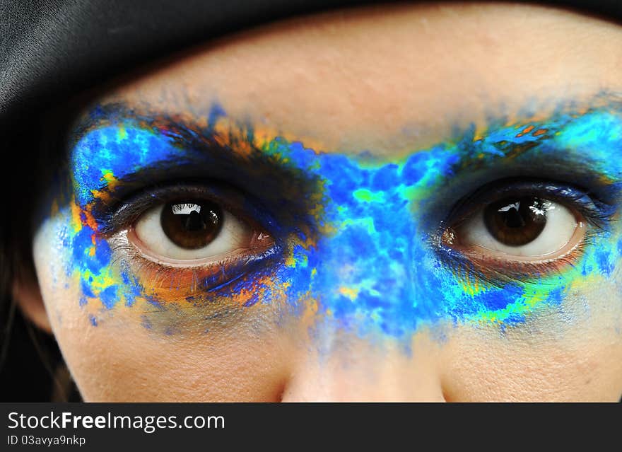 Portrait of the beautiful young girl in bright multi-coloured mask