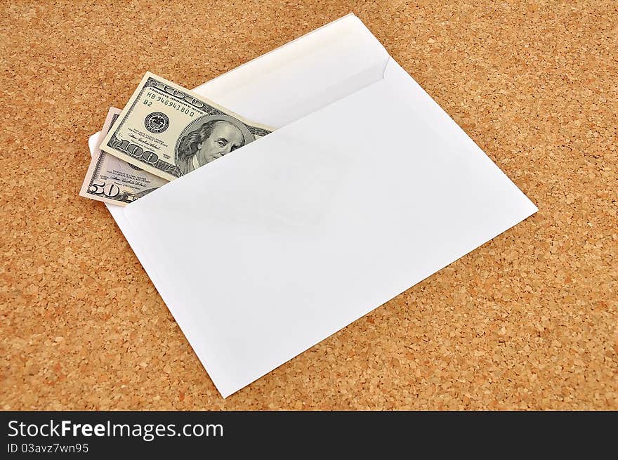 Dollars in an envelope on the cork background