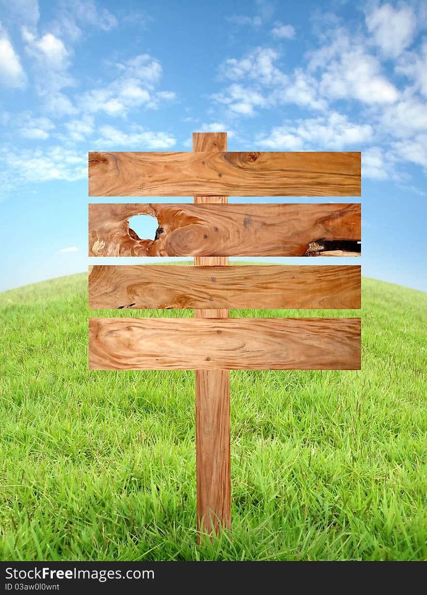 Wooden signboard with meadow and blue sky