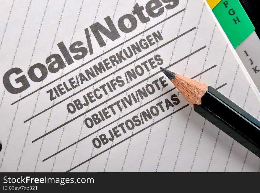 Goals plan or record in notepad and a pencil, shown as working goals, target, focus, objective important notes and other related business concept. Goals plan or record in notepad and a pencil, shown as working goals, target, focus, objective important notes and other related business concept.