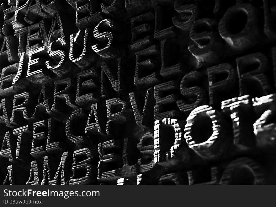 The carved wooden door of Gaudi's Sagrada Familia - close-up with the word Jesus (black and white). The carved wooden door of Gaudi's Sagrada Familia - close-up with the word Jesus (black and white)