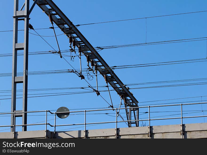 Railway gantry with high voltage cables and insulators suspended beneath.