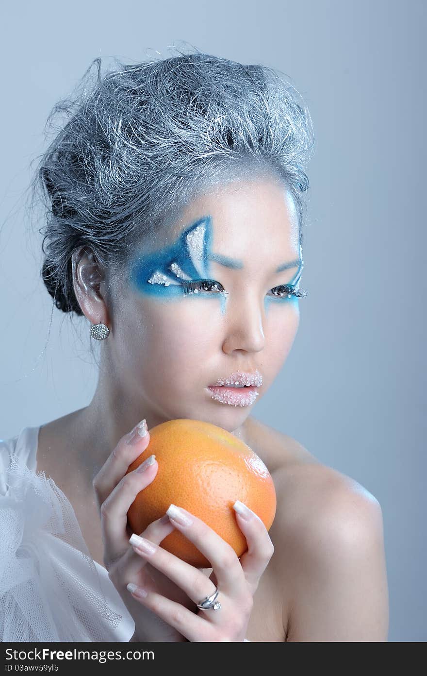 Portrait of woman with creative makeup and orange in her hands. Portrait of woman with creative makeup and orange in her hands