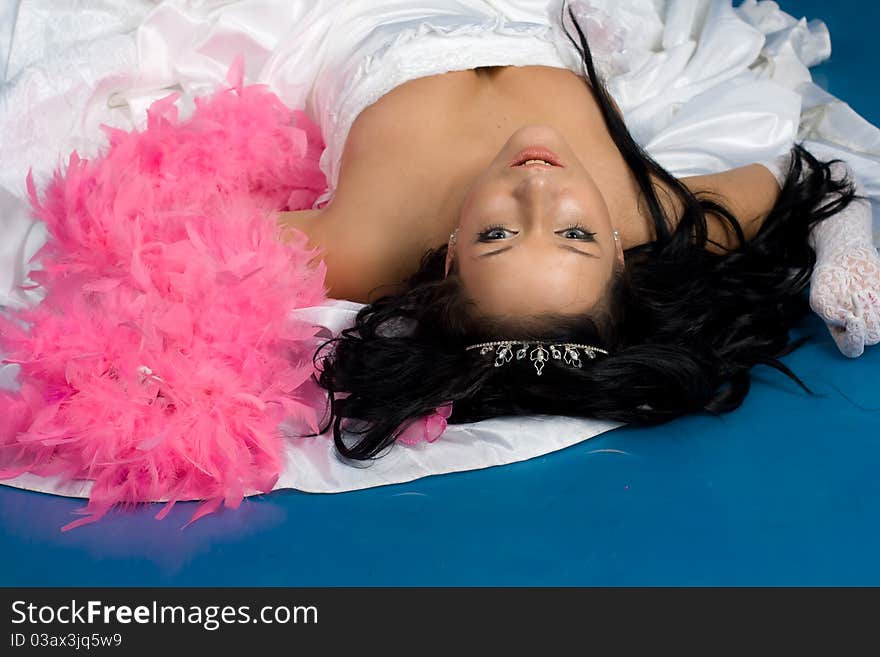 Portrait of beautiful happy bride in a wedding dress on blue background studio shot. Portrait of beautiful happy bride in a wedding dress on blue background studio shot