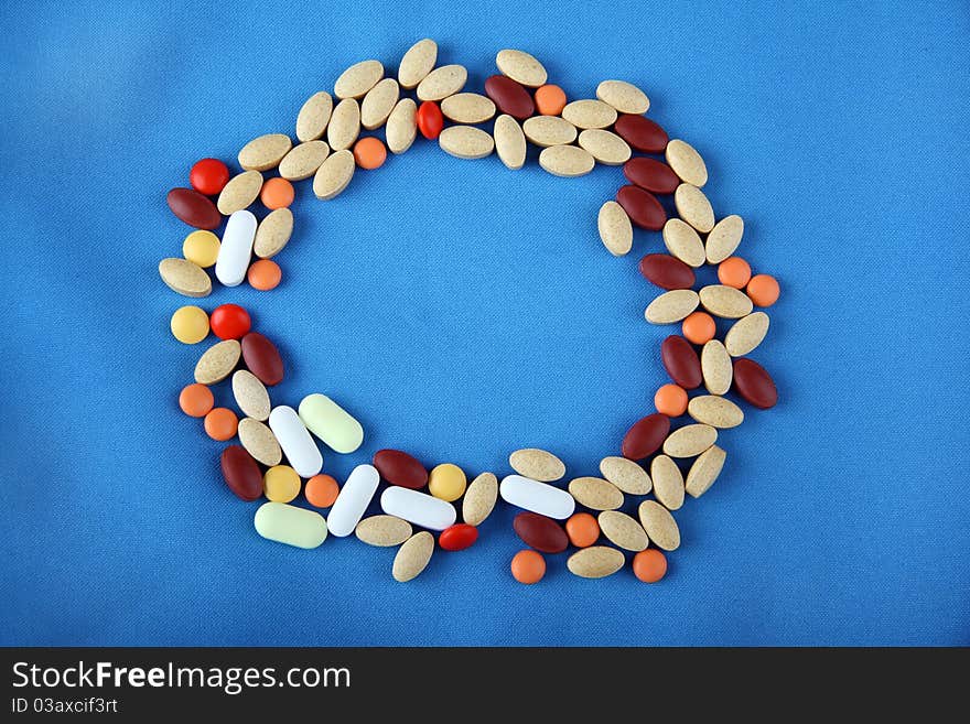 Pills forming a circle shape on blue background. Pills forming a circle shape on blue background