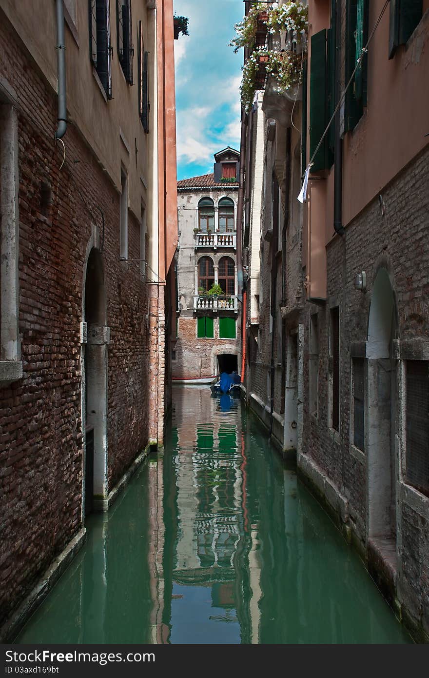 Ordinary Venetian courtyard. Canal. Daylight. Brick wall.