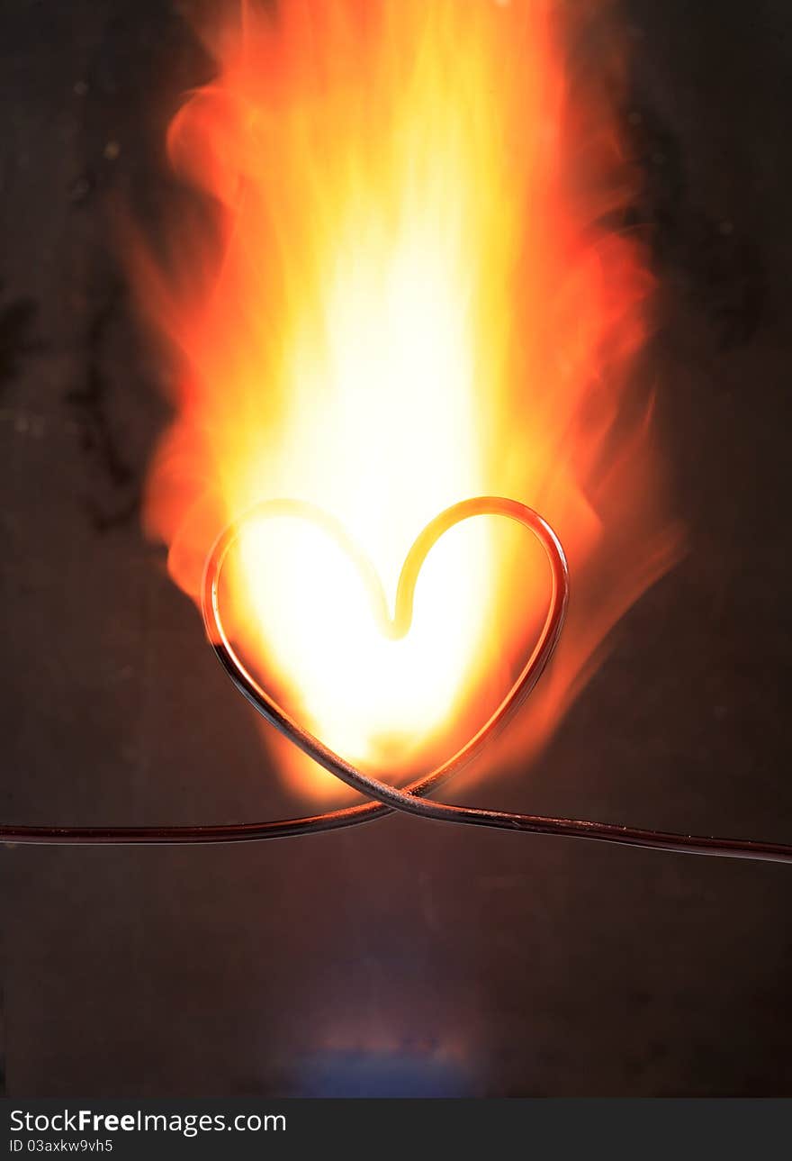 Heart made from wire in fire on dark background. Heart made from wire in fire on dark background