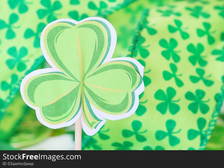 Paper shamrock decoration with shamrock ribbon in the background for St. Patrick's Day. Paper shamrock decoration with shamrock ribbon in the background for St. Patrick's Day