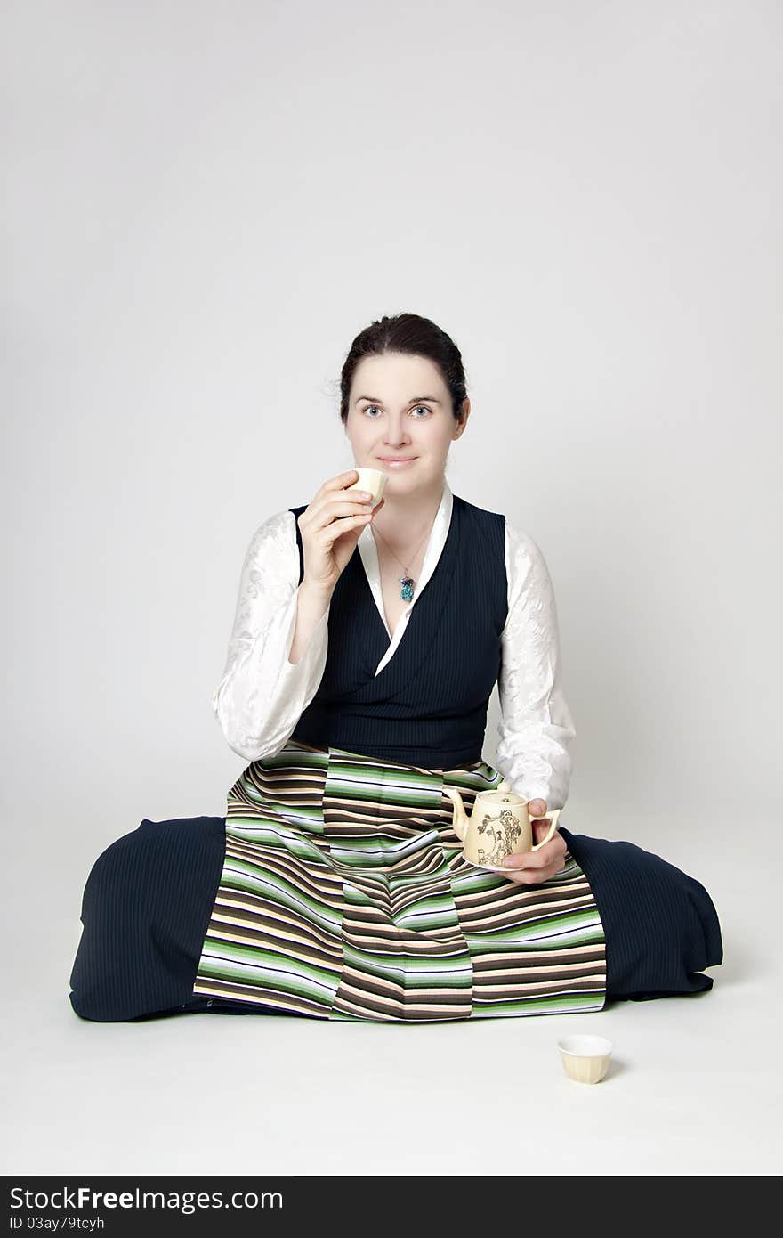 Woman in traditional tibetan dress with cup of tee