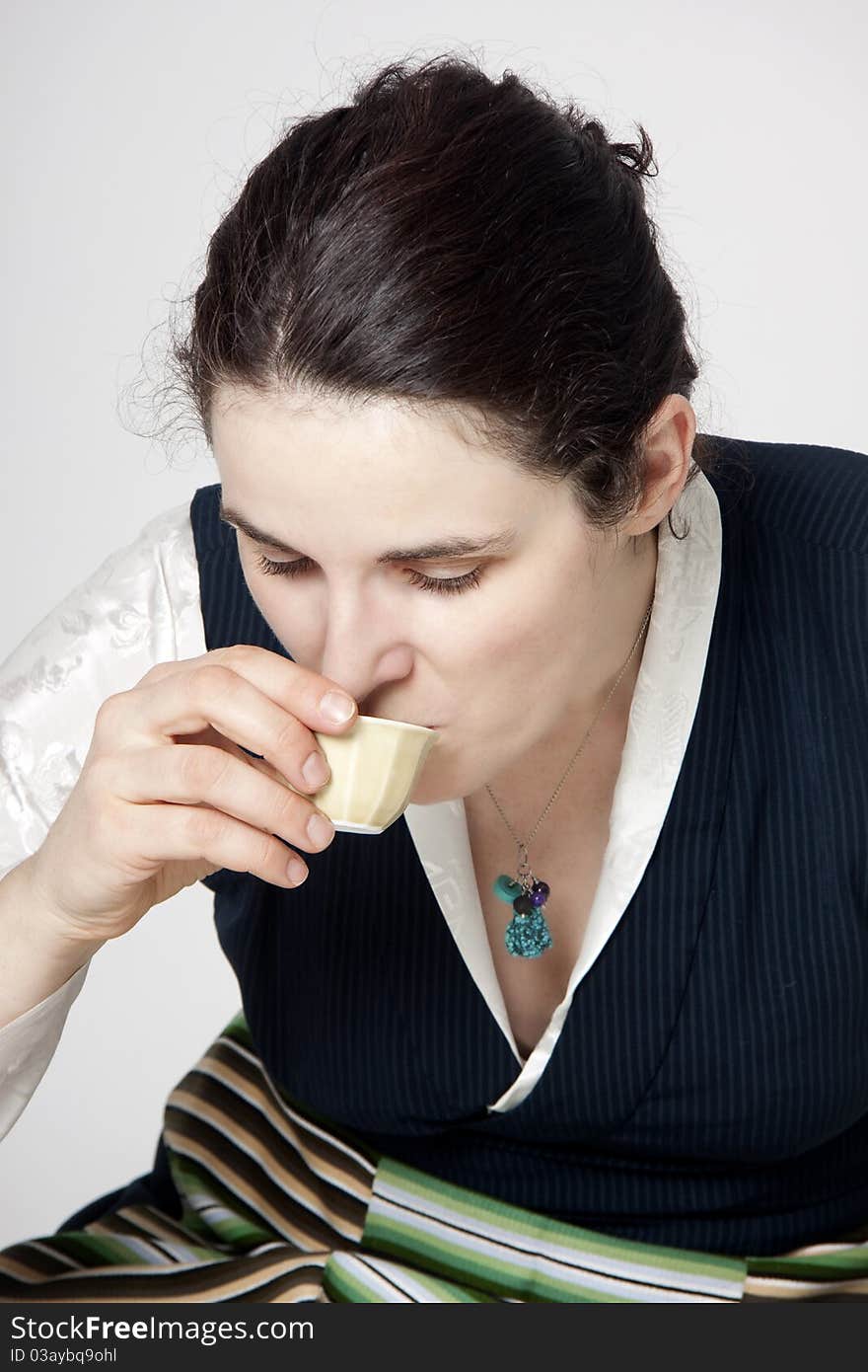 Portrait of woman in traditional tibetan dress with cup of tee