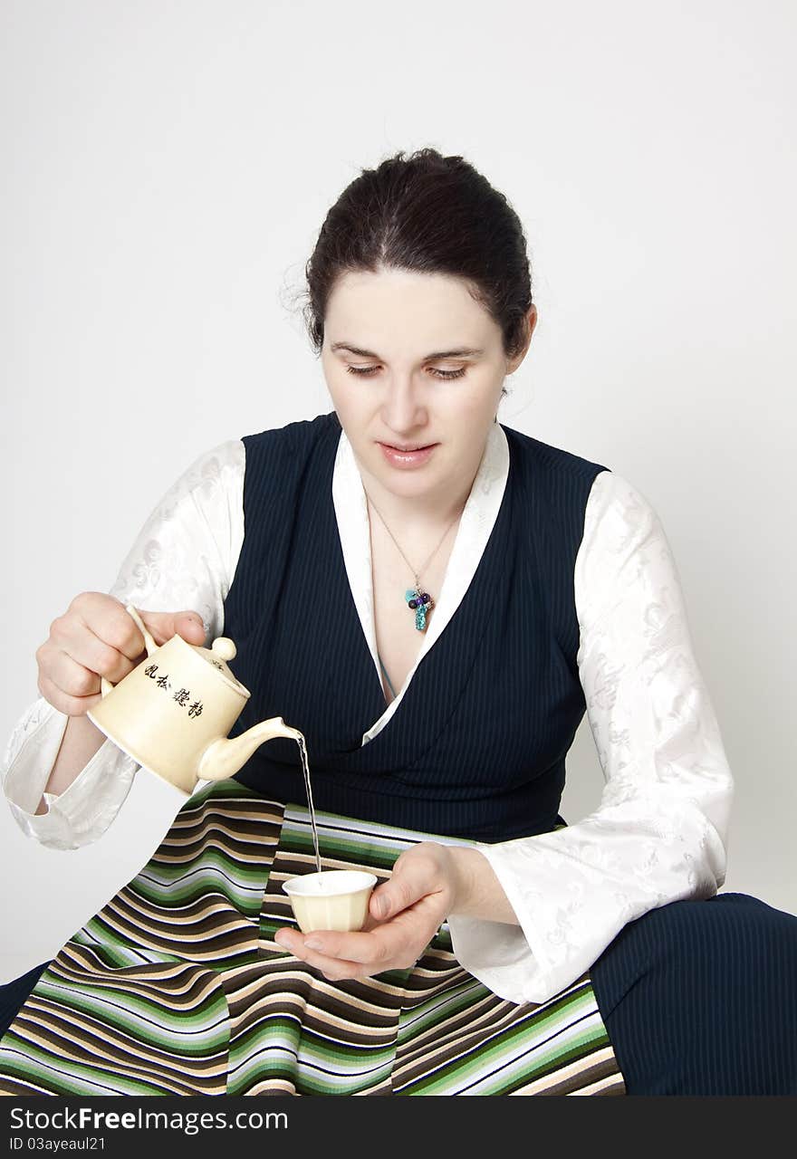 Woman in traditional tibetan dress with cup of tee