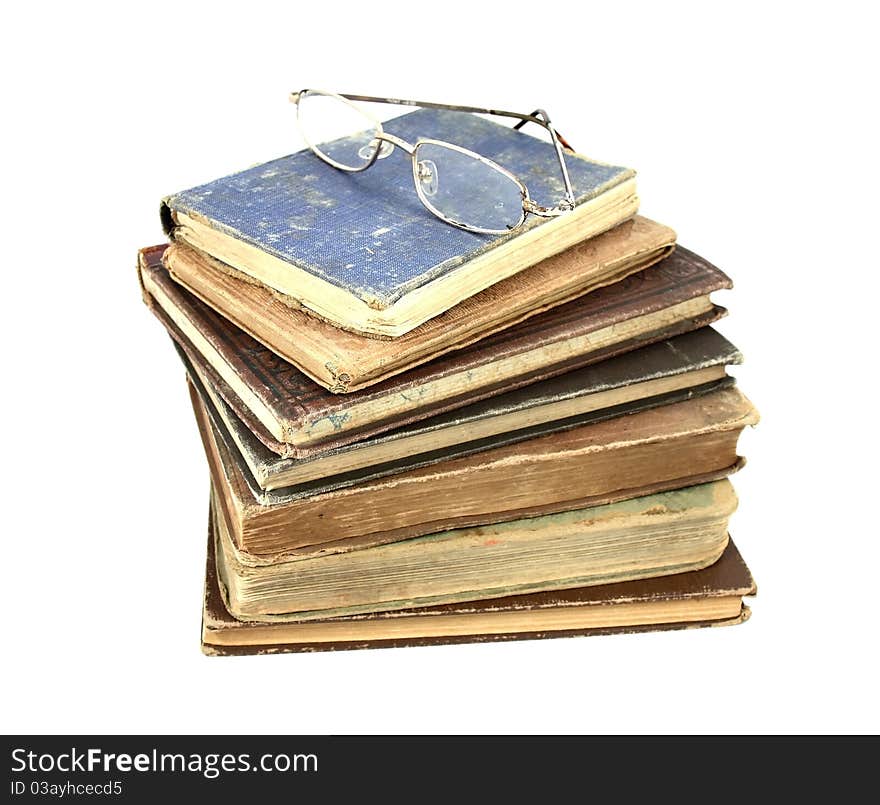 A set of antique books and old reading glasses. A set of antique books and old reading glasses.