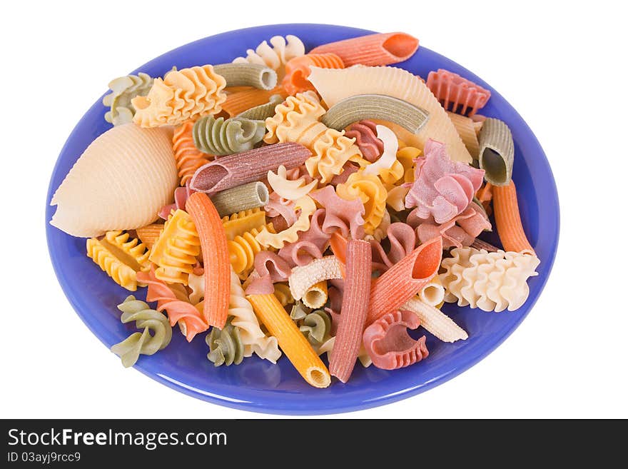 Dry color italien pasta on blue plate isolated over white background