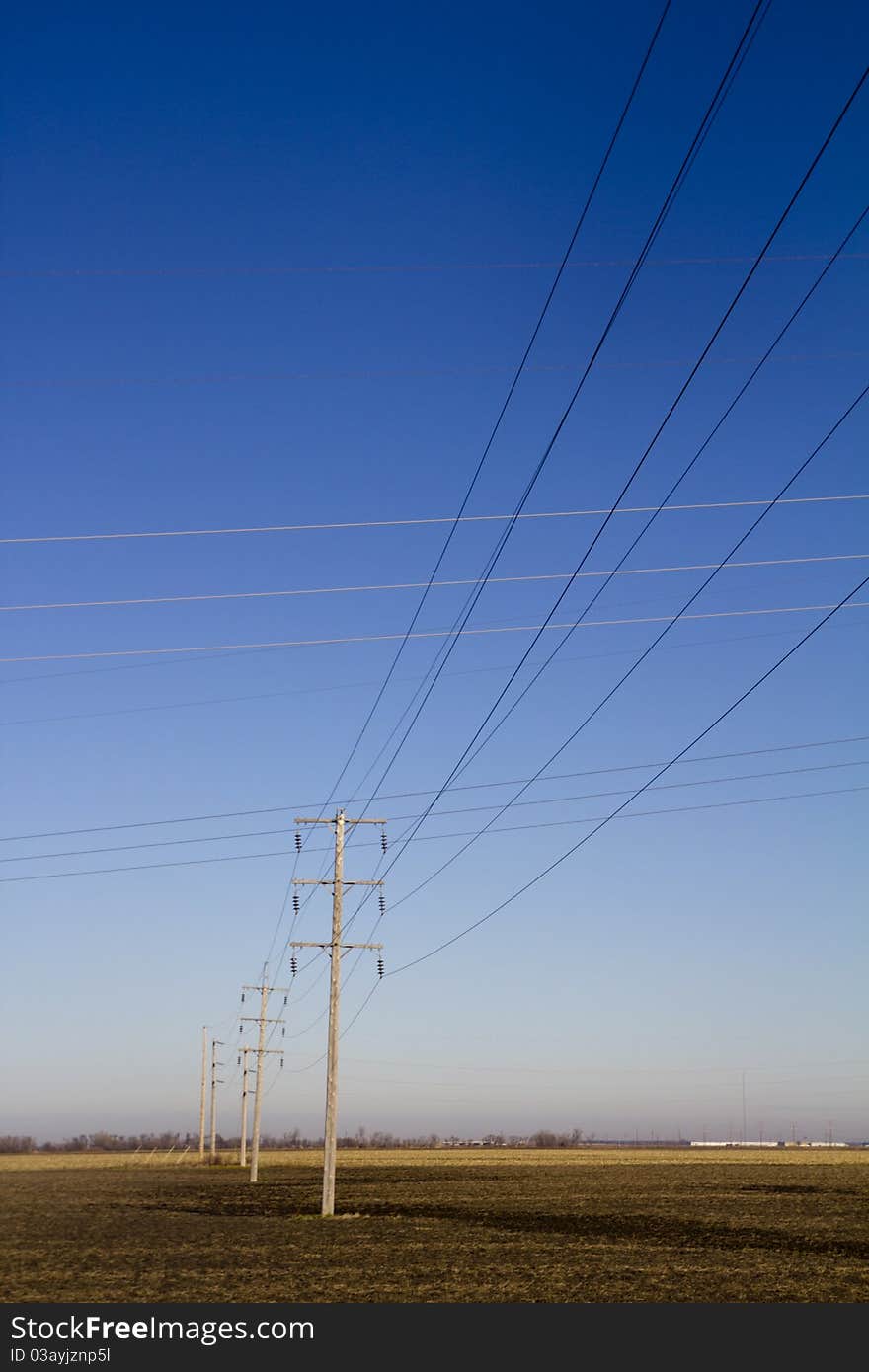 Electrical Power Lines Intersecting with Blue Sky in background