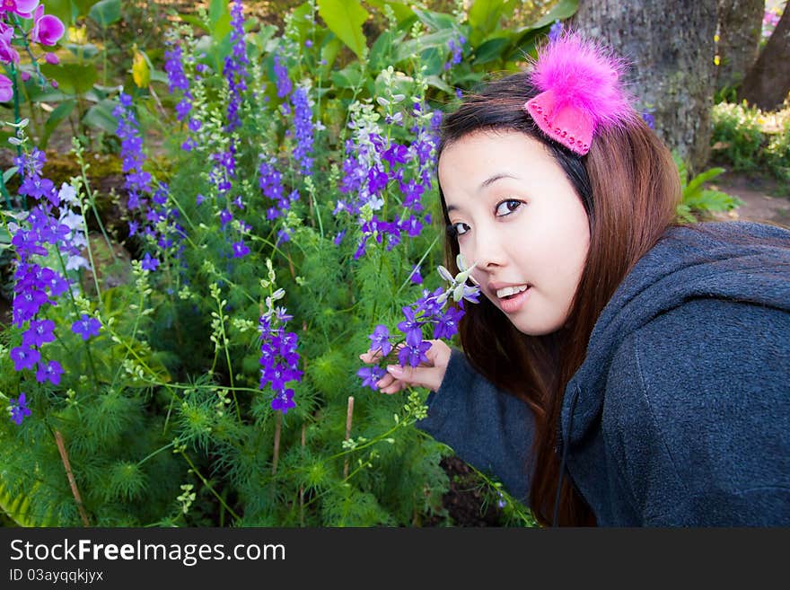 Young woman is smelling some kind of purple flowers. Young woman is smelling some kind of purple flowers