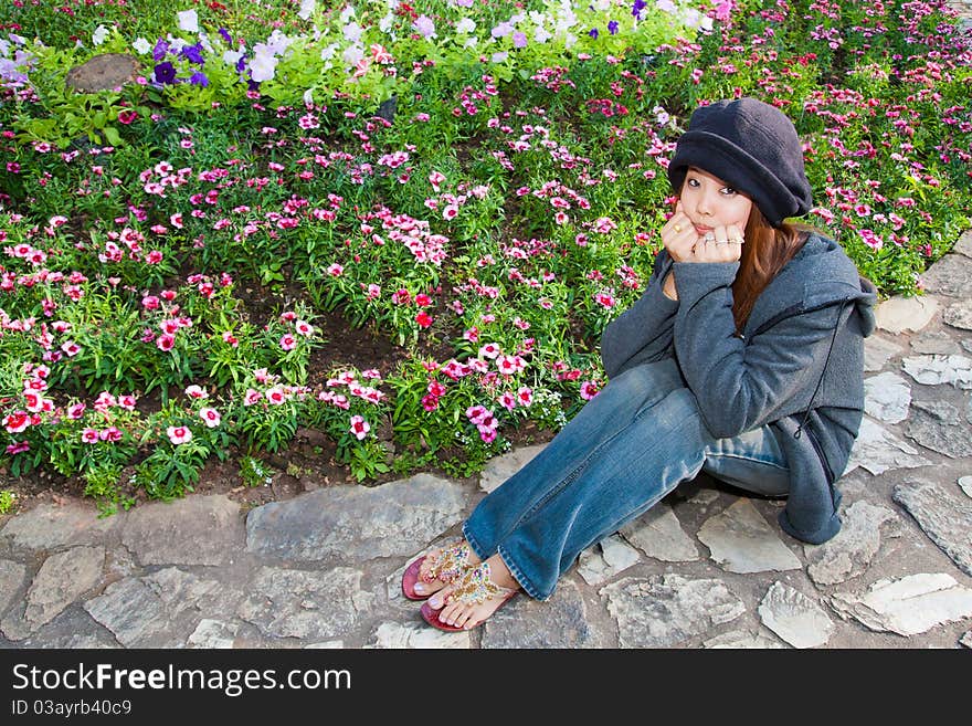 Young woman is resting her chin in hands in dianthus graden. Young woman is resting her chin in hands in dianthus graden