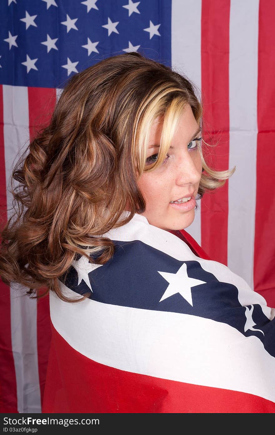 A photograph of an American lady with the American Flag in The Background. A photograph of an American lady with the American Flag in The Background.