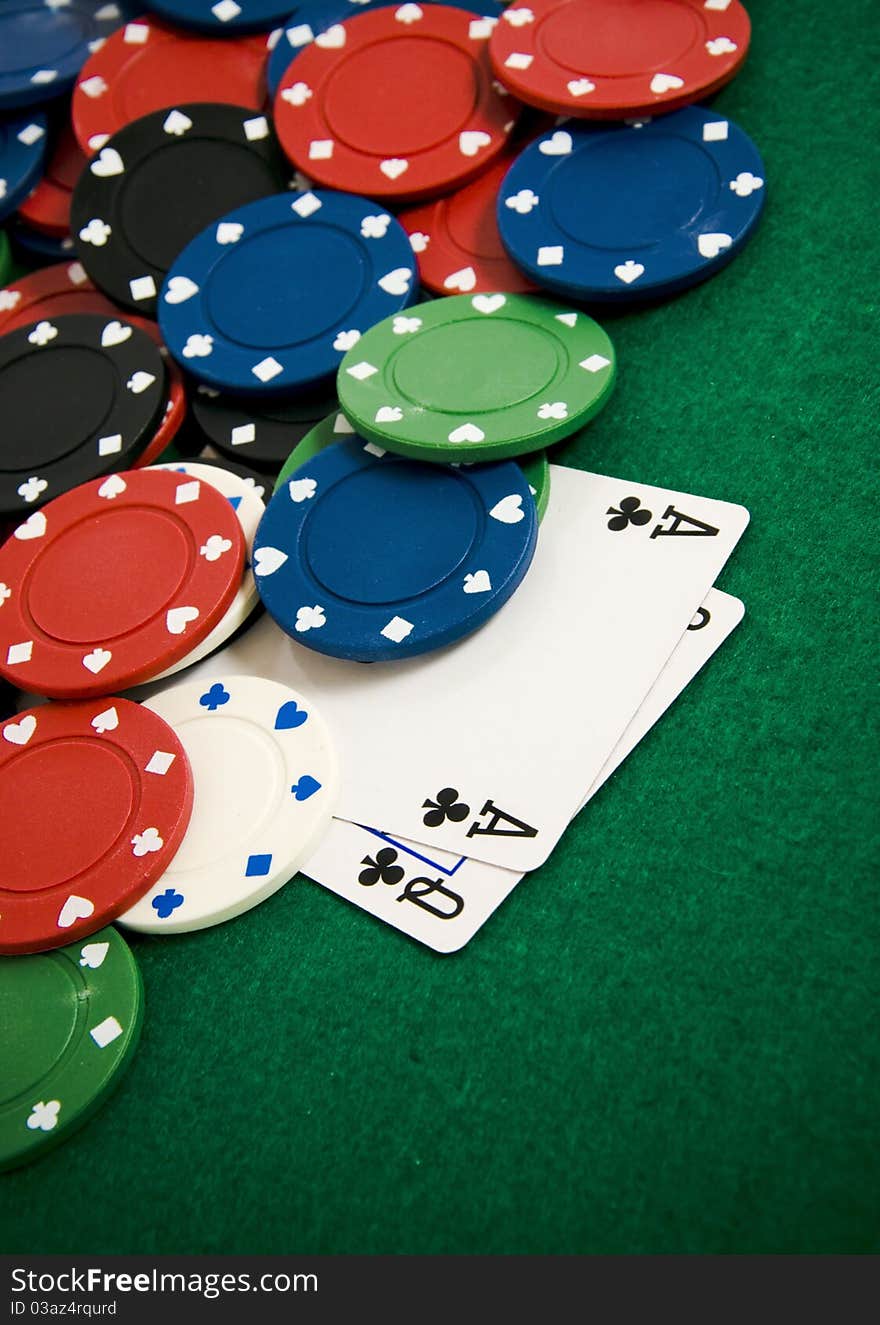 Playing cards and gambling chips on green background