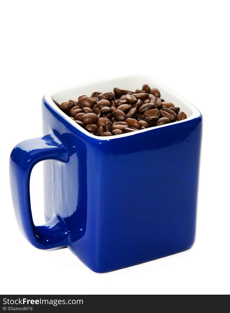 Dark blue cup with coffee grains on a white background. Dark blue cup with coffee grains on a white background