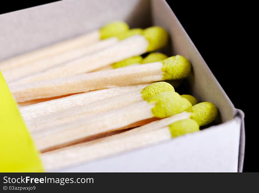 Part of green matchsticks in box isolated on black background. Part of green matchsticks in box isolated on black background.