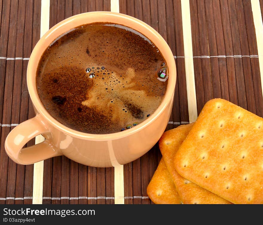 Coffee and crackers on a wooden mat