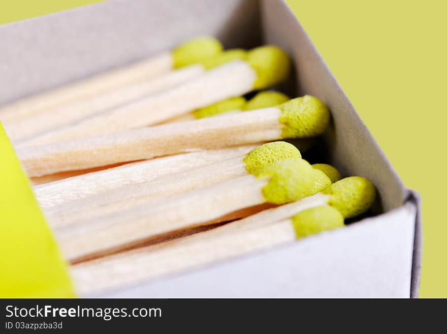 Part of green matchsticks in box isolated on green background. Part of green matchsticks in box isolated on green background.