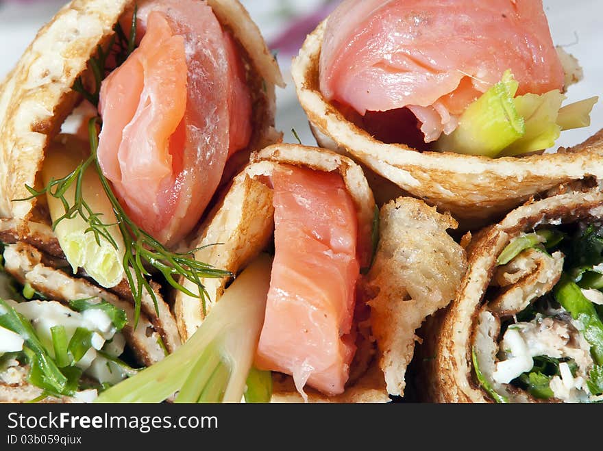 On a table there is a plate with pancakes and red fish. On a light background. On a table there is a plate with pancakes and red fish. On a light background