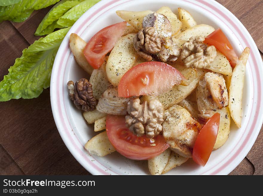 Dish with potatoes and chicken, tomatoes and walnuts. Dish with potatoes and chicken, tomatoes and walnuts