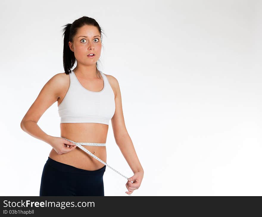 Shocked woman measuring waist