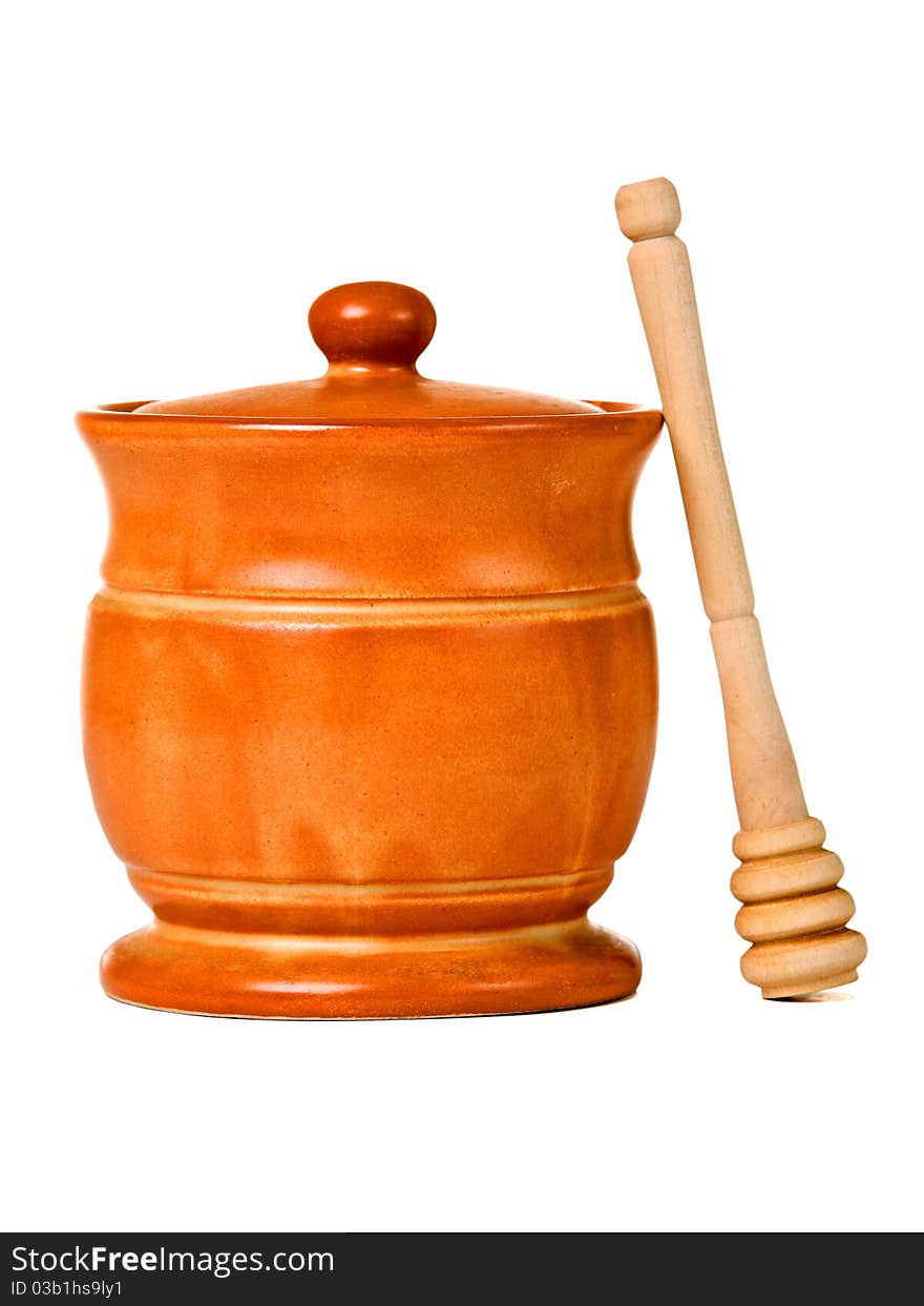 Ceramic jar with honey and wooden stick