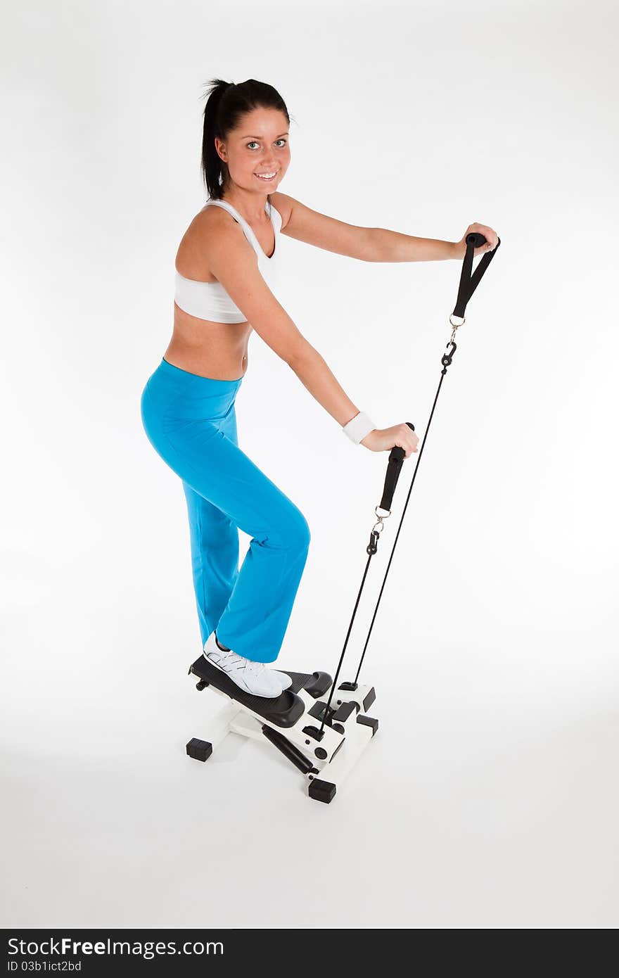 Young woman exercising on stepper trainer, vertical. Young woman exercising on stepper trainer, vertical