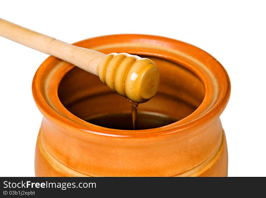 Ceramic jar with honey and wooden stick