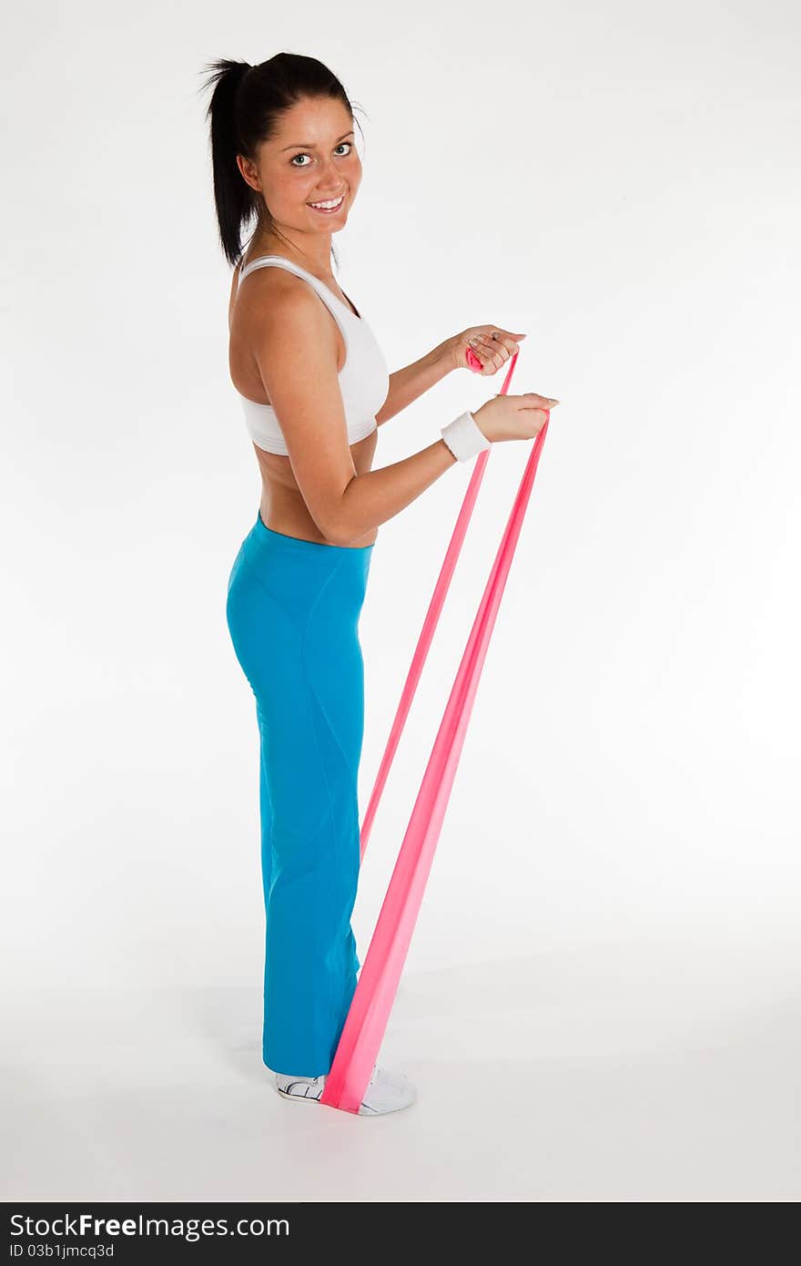 Young woman exercising with rubber ribbon, vertical