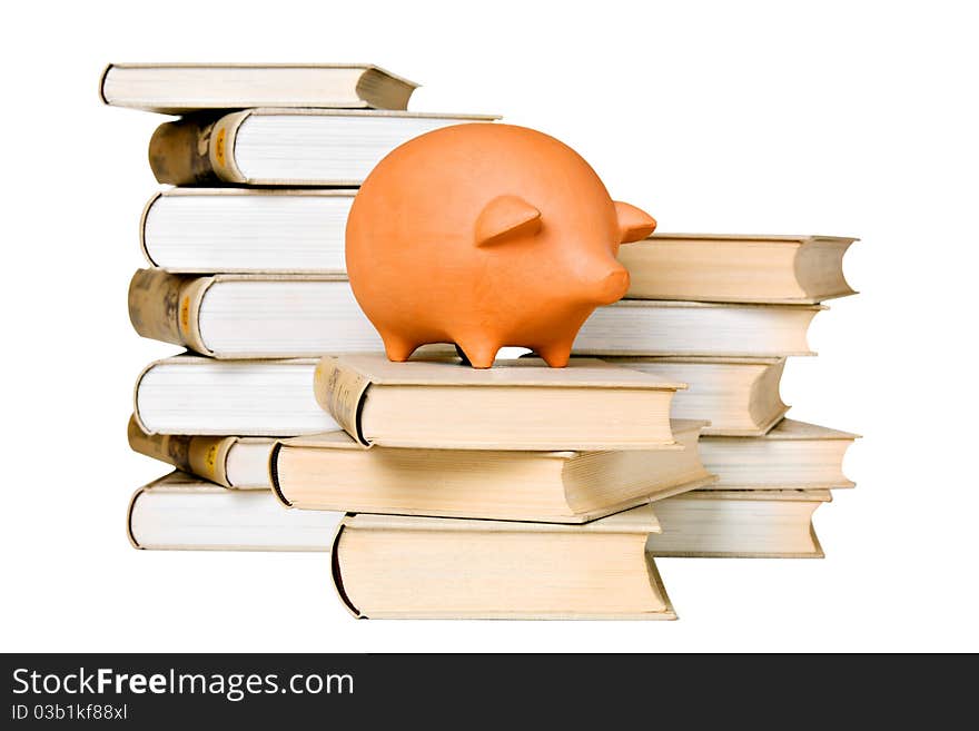 Clay piggy bank and old-fashioned books, isolated on white