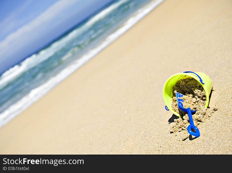 Toy bucket and shovel on an empty beach