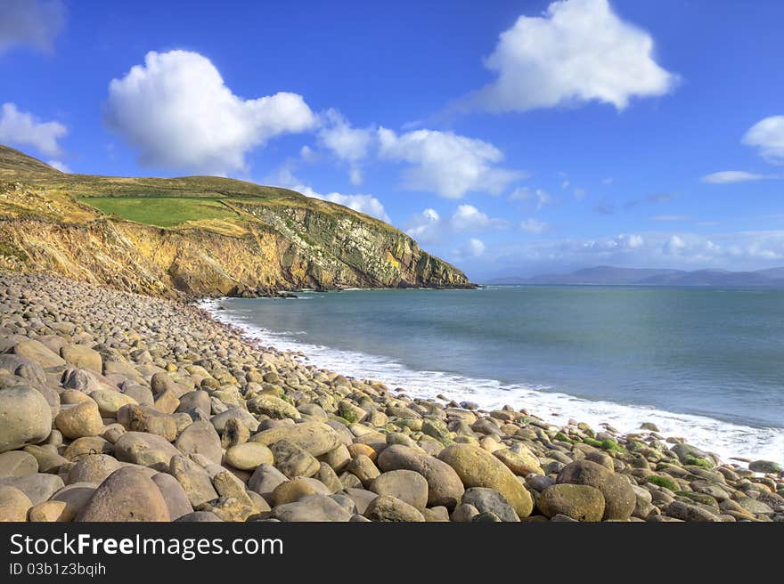 A stone beach with cliffs in background, Ireland.