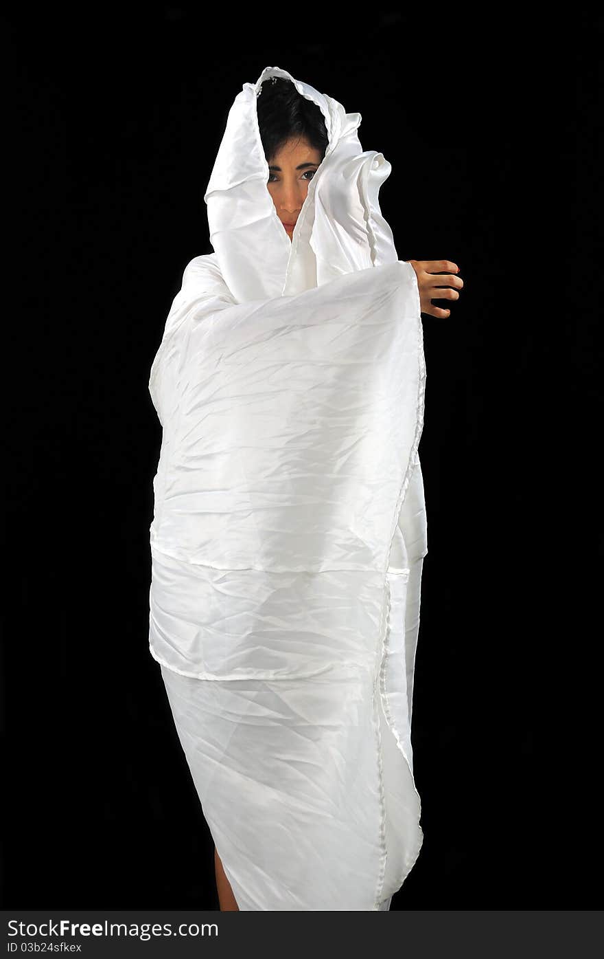 Portrait of a woman wrapped in white fabric isolated on black. Portrait of a woman wrapped in white fabric isolated on black