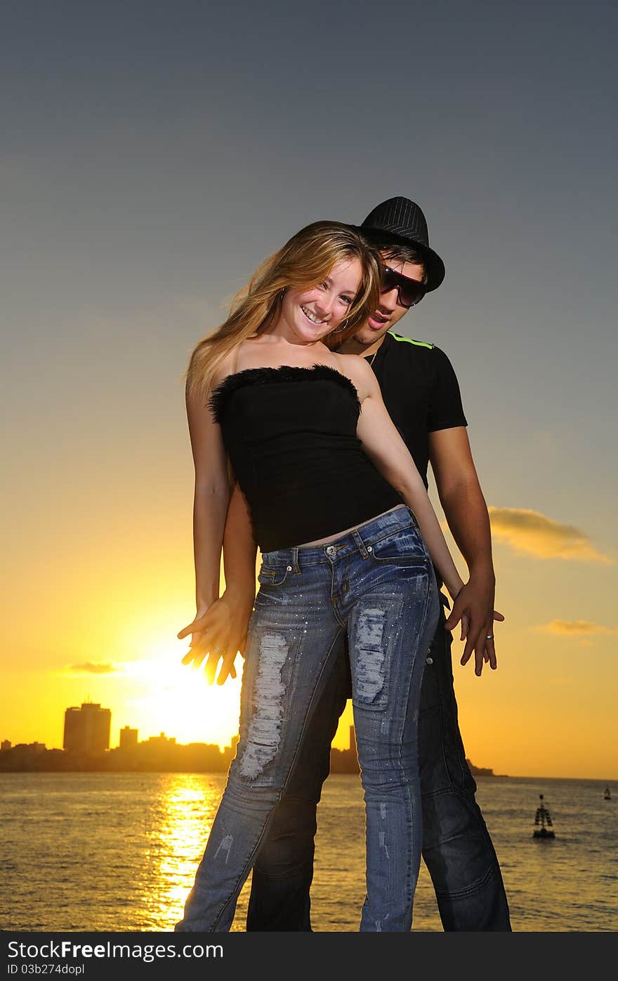 Portrait of young cheerful hispanic couple standing at sunset. Portrait of young cheerful hispanic couple standing at sunset