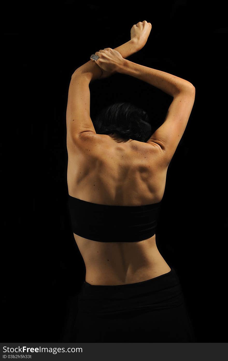 Abstract female back with black top isolated on black background. Abstract female back with black top isolated on black background