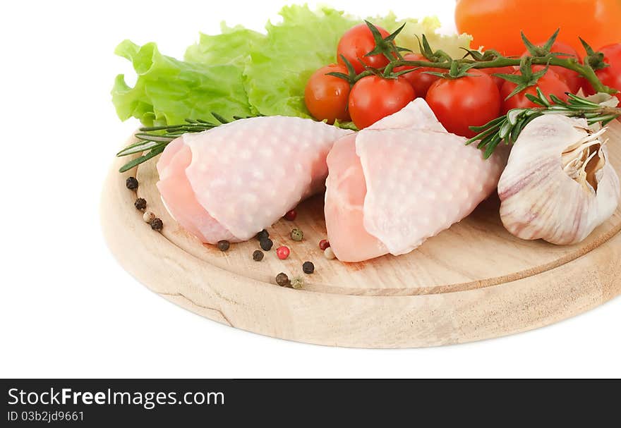 Chicken drumsticks with vegetables on the cutting board