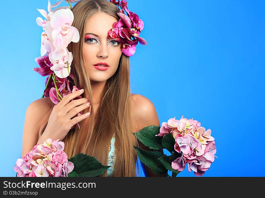 Portrait of a beautiful tanned woman in bikini posing with flowers. Portrait of a beautiful tanned woman in bikini posing with flowers.